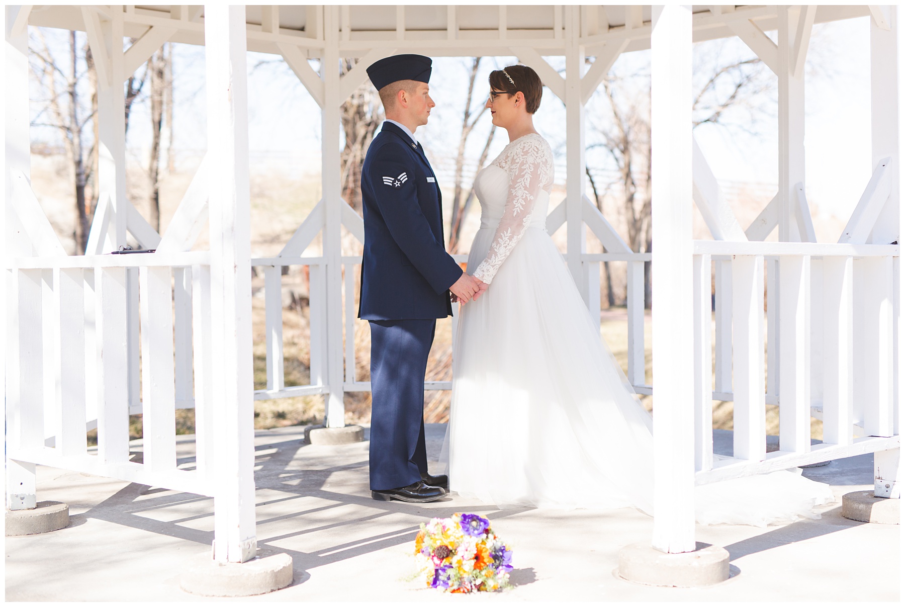 Military bride and groom in white gazebo