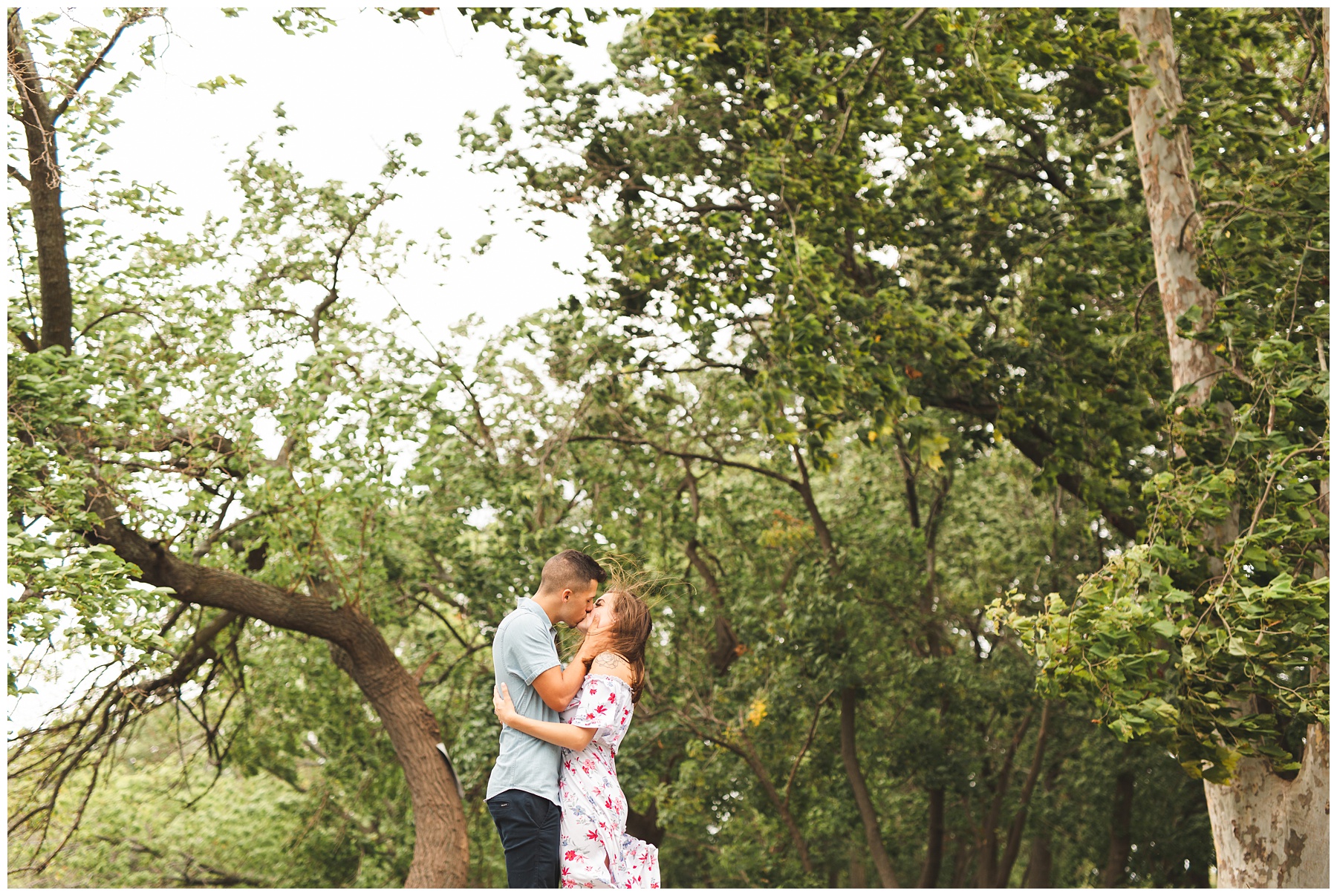 couple kissing among the trees during engagement session at Long Dock Park in Beacon NY
