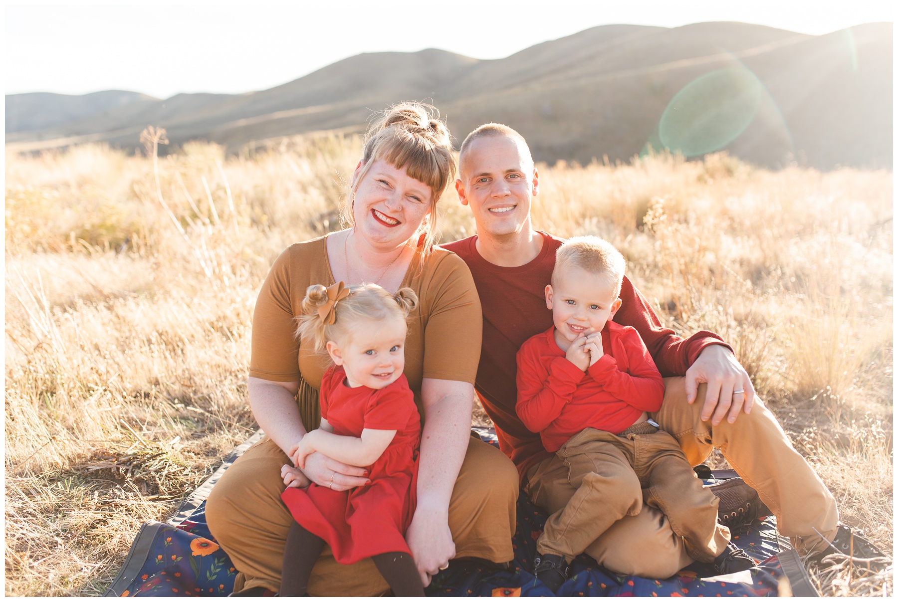 Family in fall colors sitting on the golden grass in Pine Idaho