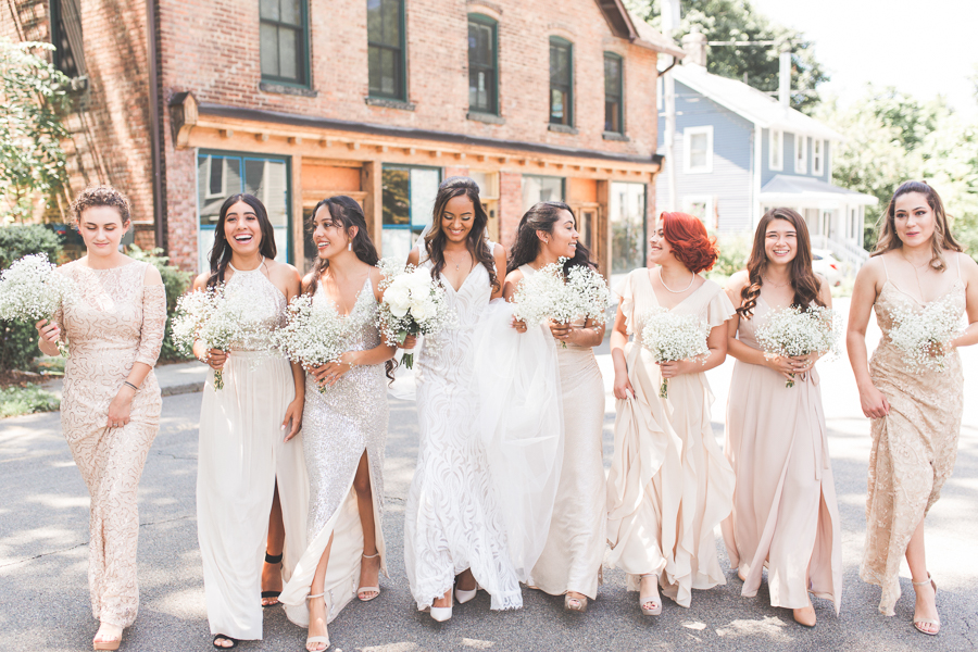 bride and bridesmaids walking toward the camera in blush and nude colors photo by Miranda Renee Photography
