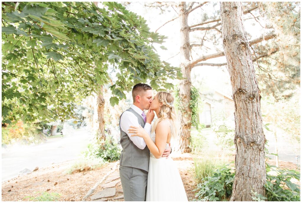 bride and groom kissing in the trees 
