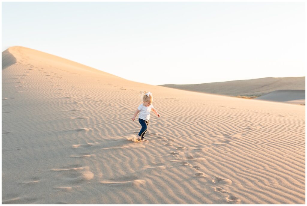sunset family photos 2 year old girl running in the sand in Boise Idaho