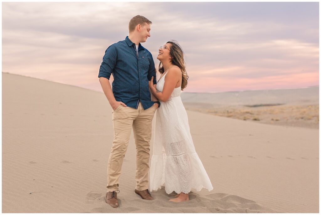 Sand Dunes engagement session. Engaged couple with beautiful sunset behind them photo by Miranda Renee Photography in Mountain Home Idaho