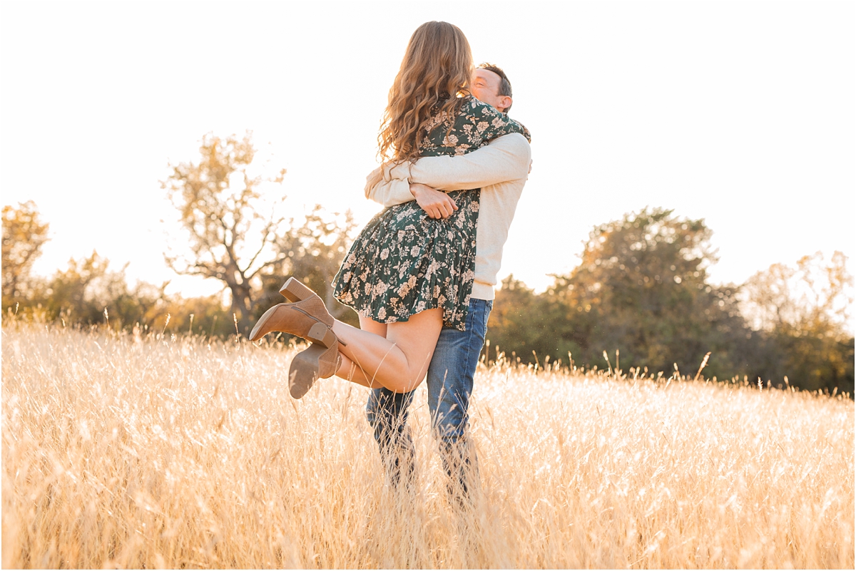 Engaged couple spinning around in a wheat field at sunset Miranda Renee Photography