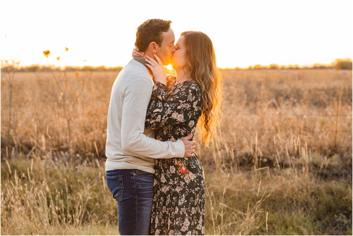 Couple kissing with the sun peeking through between their faces. destination engagement photos