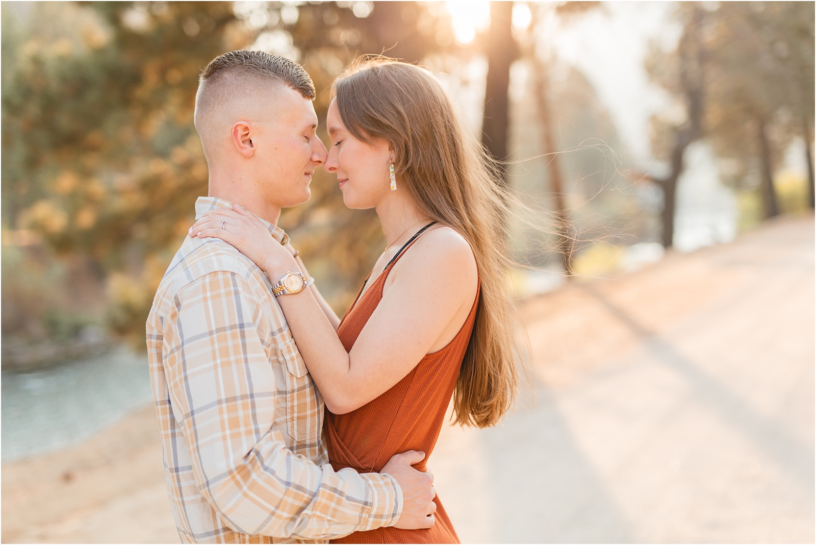 engaged couple touching noses in Pine Idaho during their Couples' Photo Session with the sunset behind them