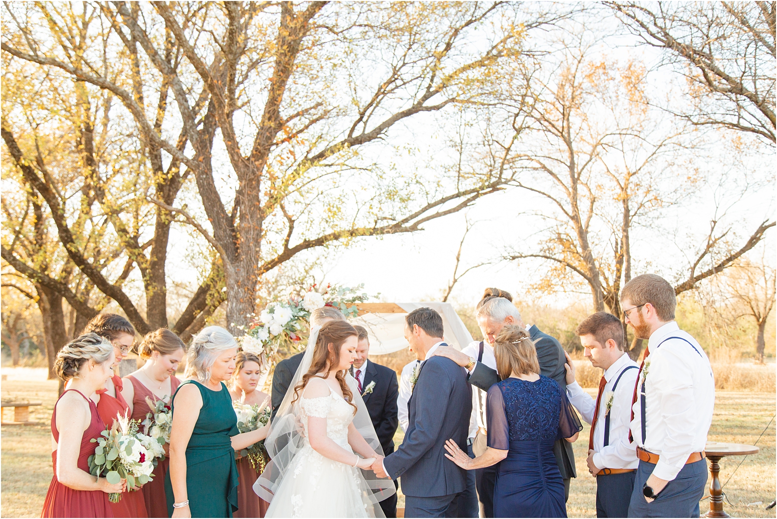 family praying around bride and groom in Idaho destination wedding