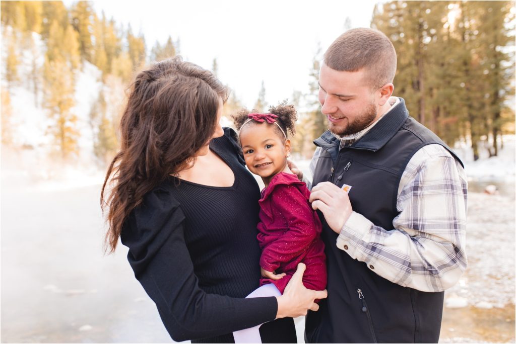 Couple looking at their daughter between them, daughter looking at camera. Boise engagement photos