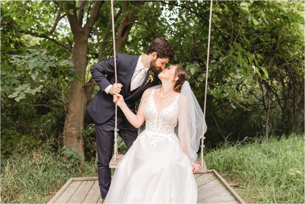 bride and groom kissing on swing