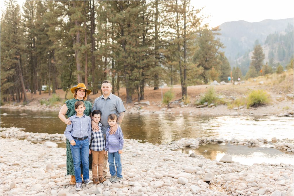 family with 3 boys standing by a river in Pine Idaho