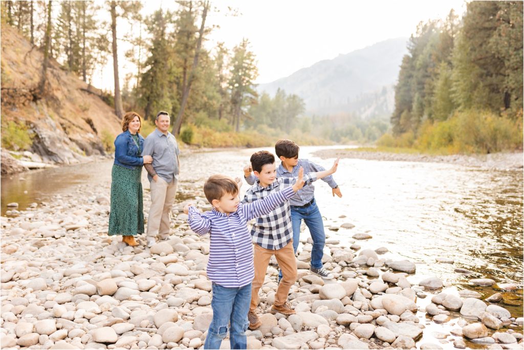boys throwing rocks in the river for their family photos