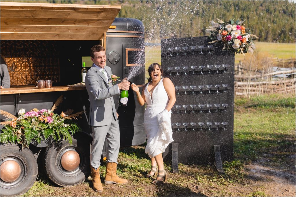couple popping champagne at longhorn guest ranch
