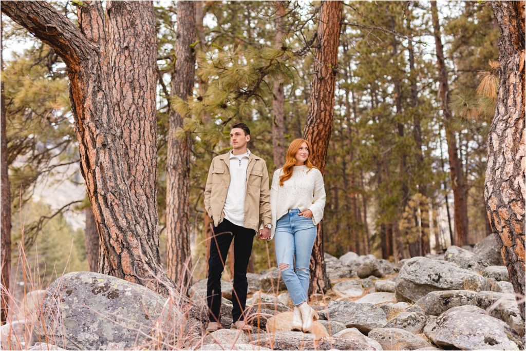 engaged couple standing among trees in Boise