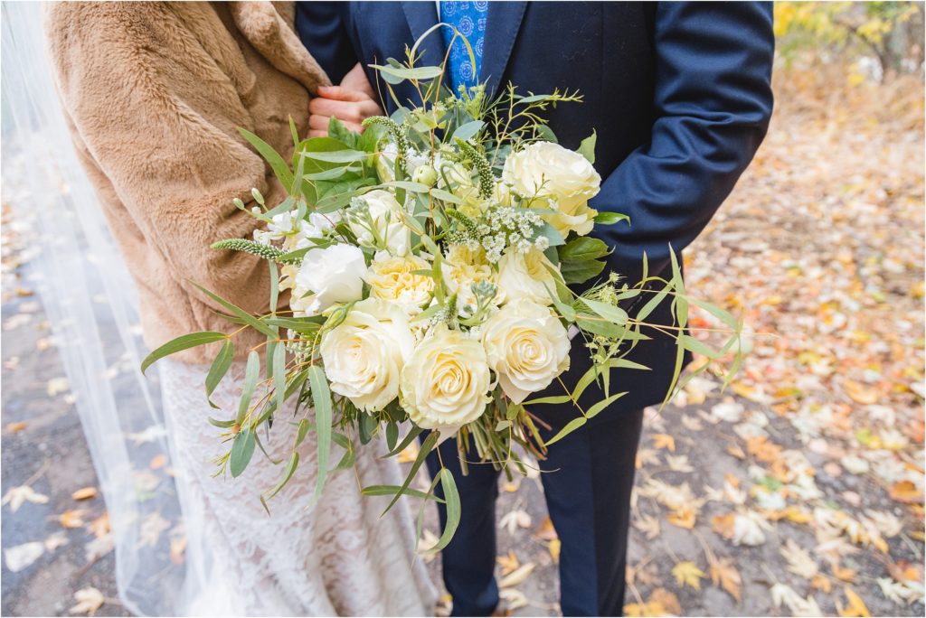 bride and groom holding autumn wedding bouquet