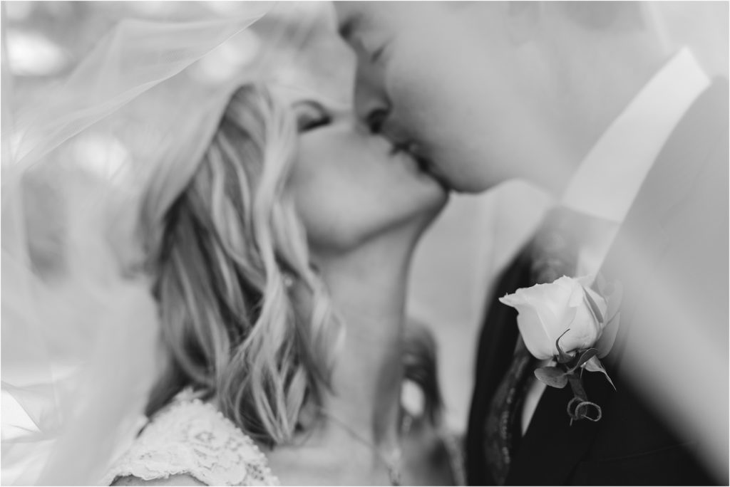 black and white creative wedding photo of couple kissing