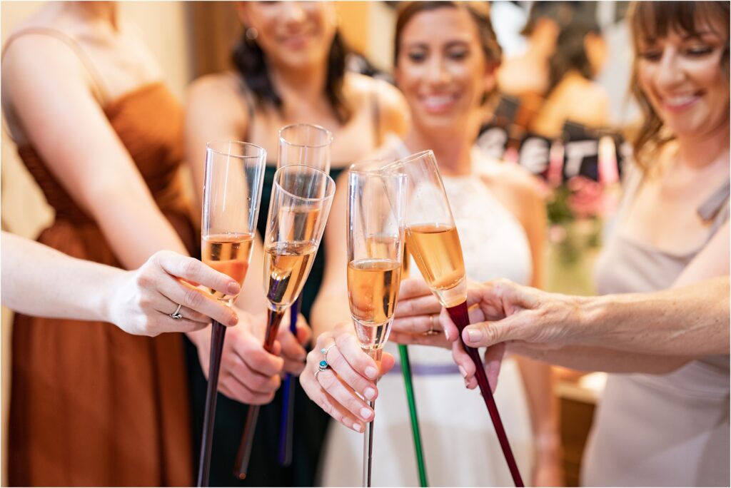 bride and bridesmaids cheersing with champagne 
