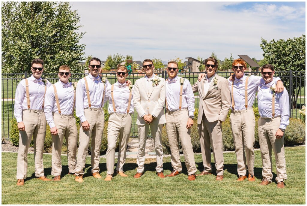 groom and groomsmen in beige suits with sunglasses