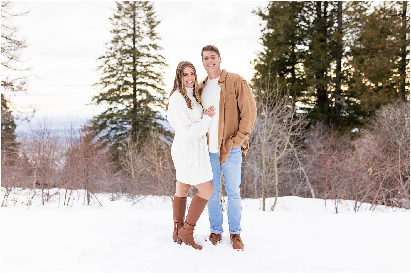 couple in cream and tan looking at the camera in the snow