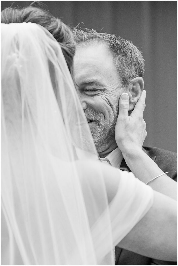 black and white photo of bride cupping grooms face