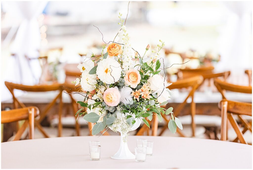 Wedding reception table center piece of peach and ivory flowers