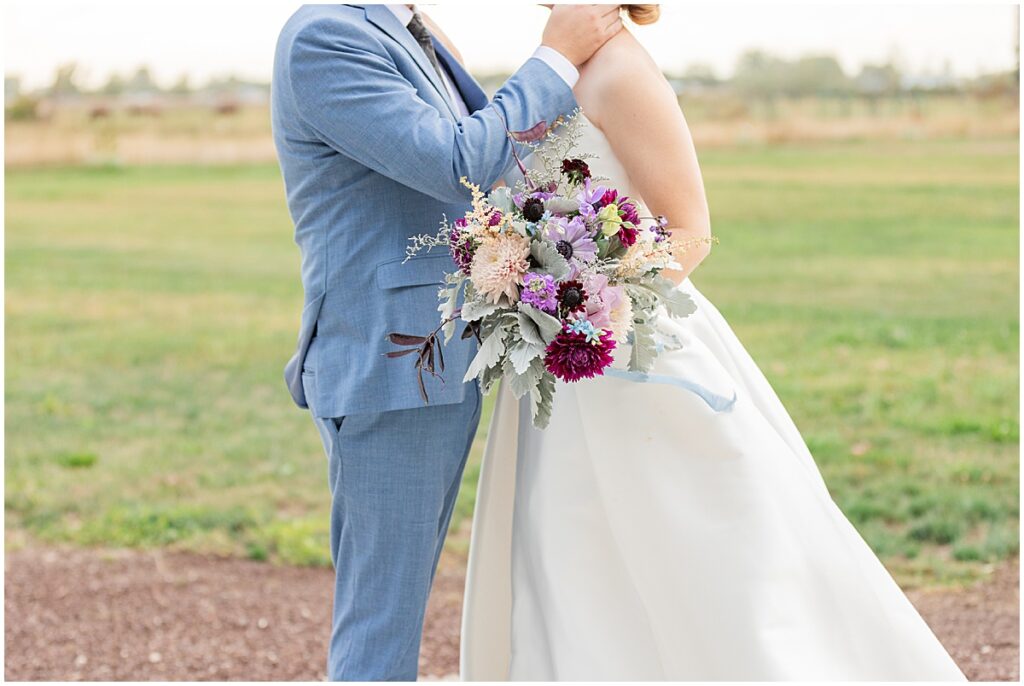 groom in blue suit holding bride. Elegant Wedding at Magnolia Cottage